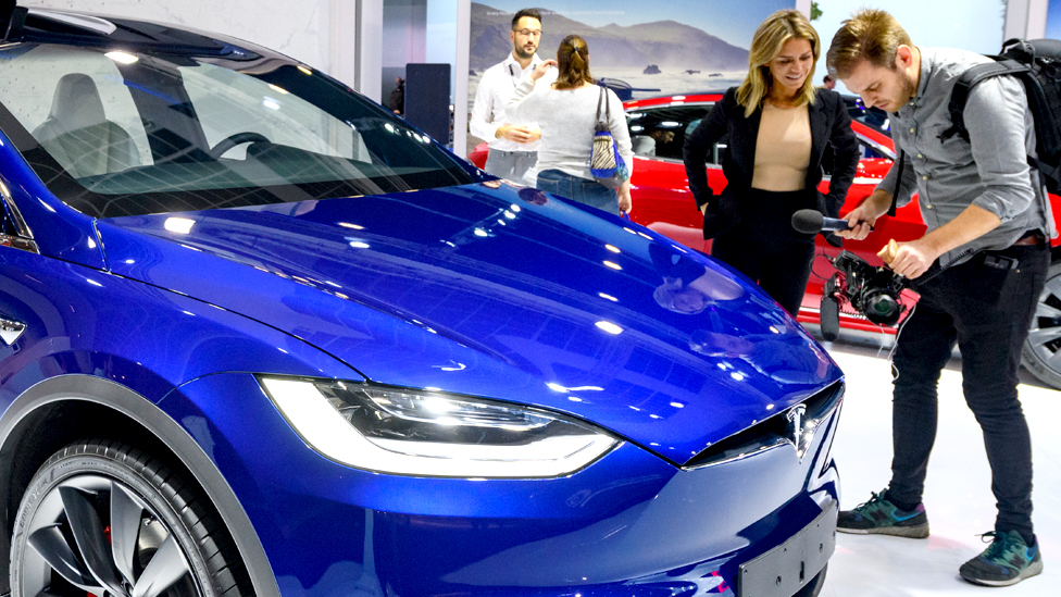 Picture of people around a Tesla EV