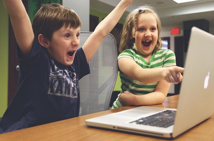 the merge, two children in front of a computer